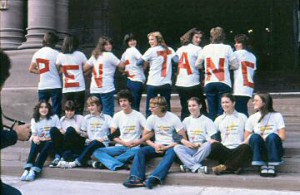 Une vingtaine d'étudiants à Queen's Park, vêtus de chandails arborant de grosses lettres rouges : P-E-N-E-T-A-N-G