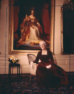 Madame Pauline Archer Vanier devant un grand tableau de la Reine Victoria.  Source: Bibliothèque et Archives Canada
